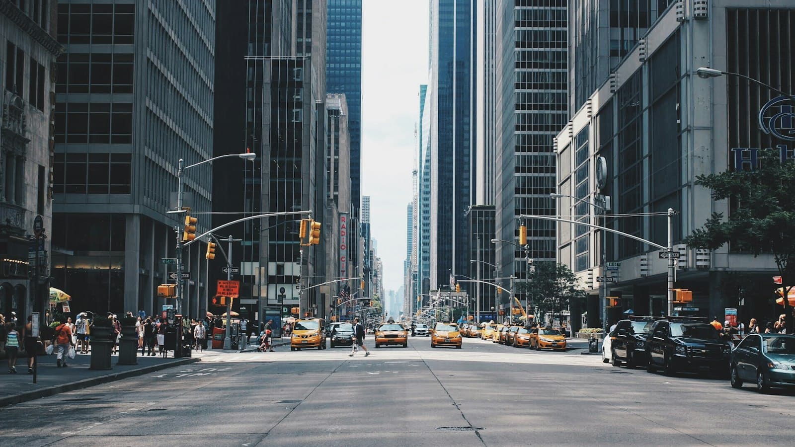 Busy city street with tall buildings and pedestrians