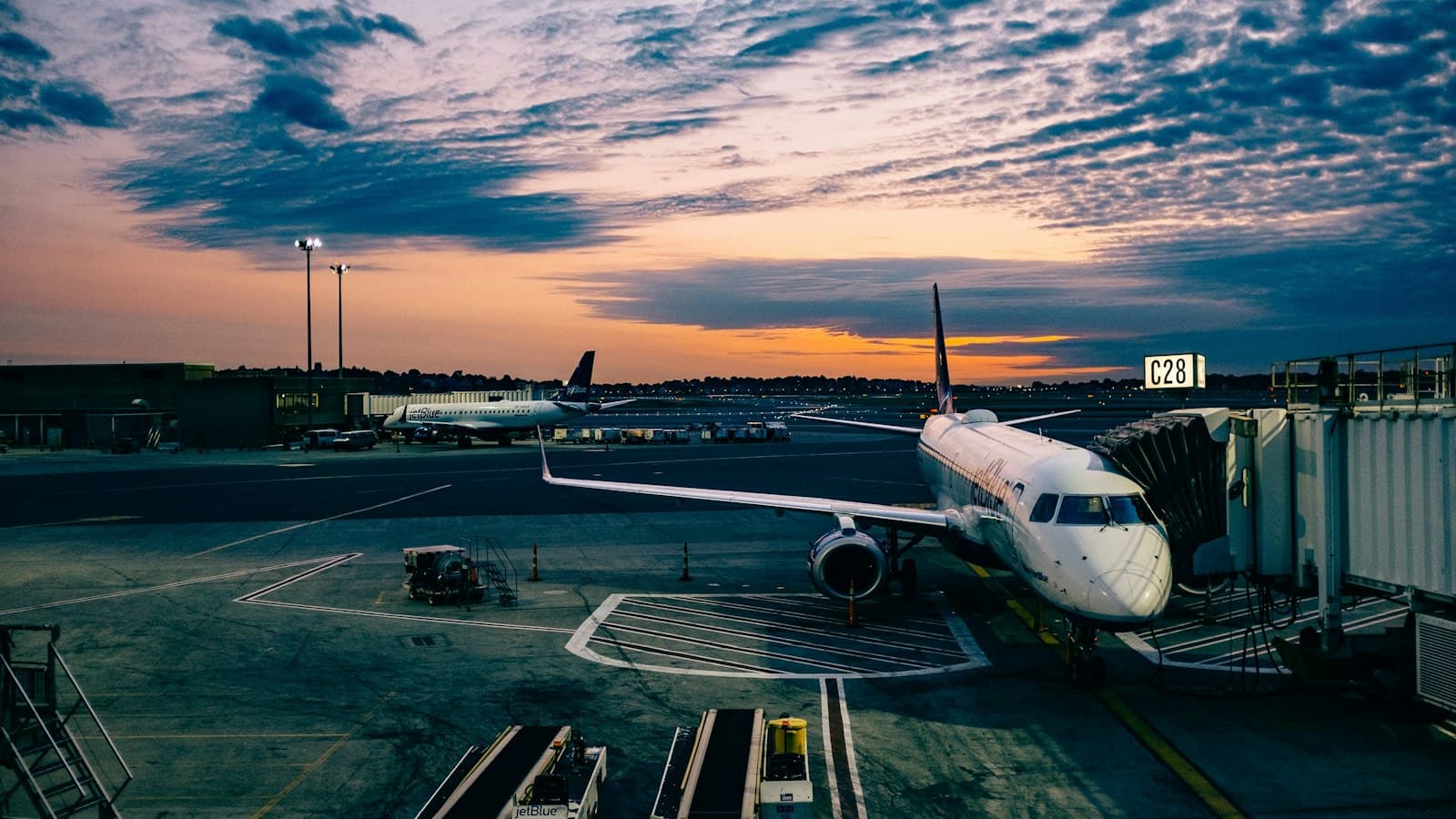 Airliner parked at a sunset airport gate