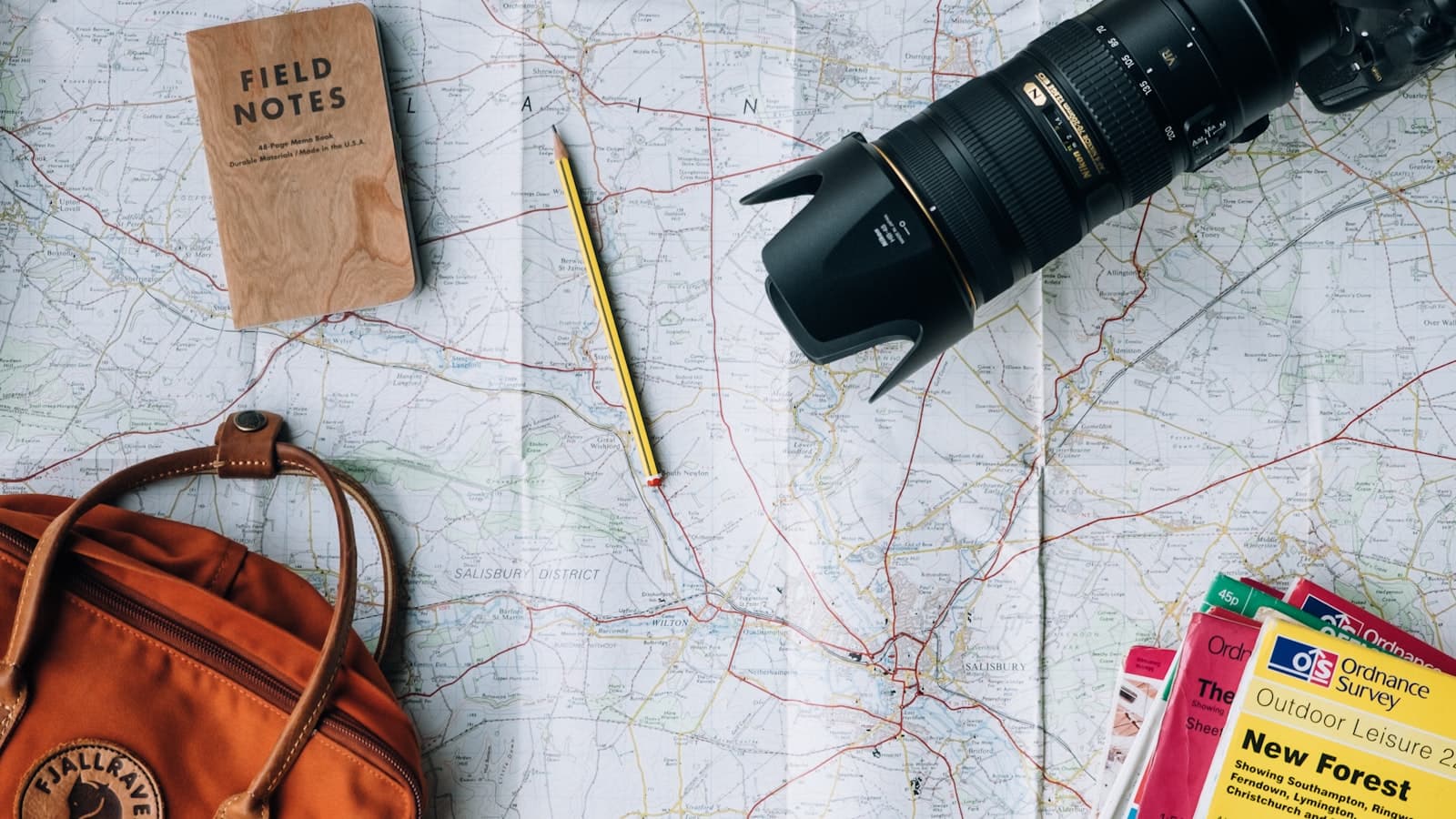 Travel backpack, camera, and folded map on a table